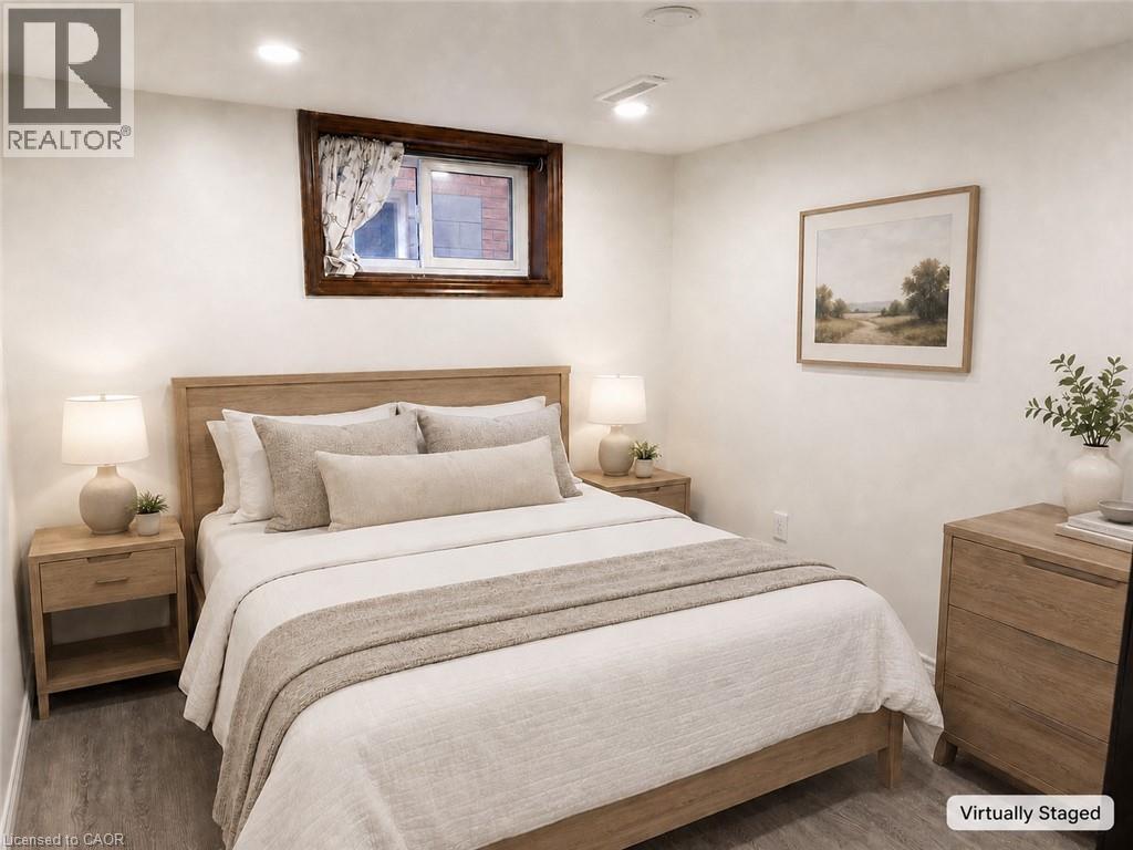 Bedroom featuring light-toned wood-finish flooring, recessed lighting, and a window with dark wood trim - 102 Juniper Drive, Hamilton, ON