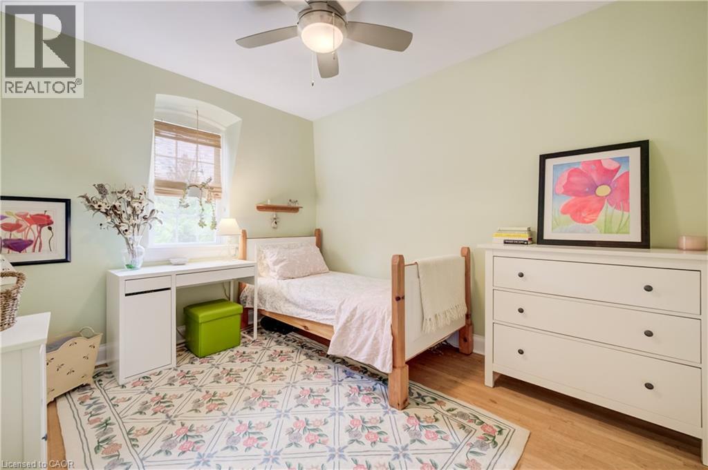 Recessed window with wood-finish blinds, light green walls, and wood-finish flooring - 314 Glasgow Street, Kitchener, ON