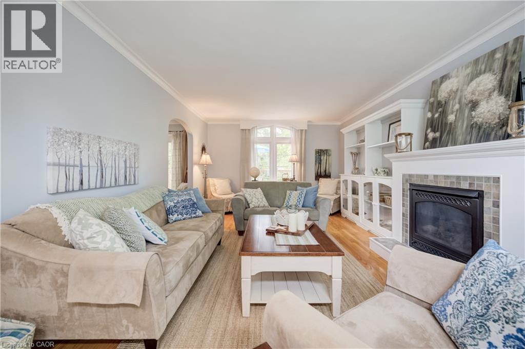 Living area featuring wood-finish flooring, crown molding, and a fireplace with a tiled surround - 314 Glasgow Street, Kitchener, ON