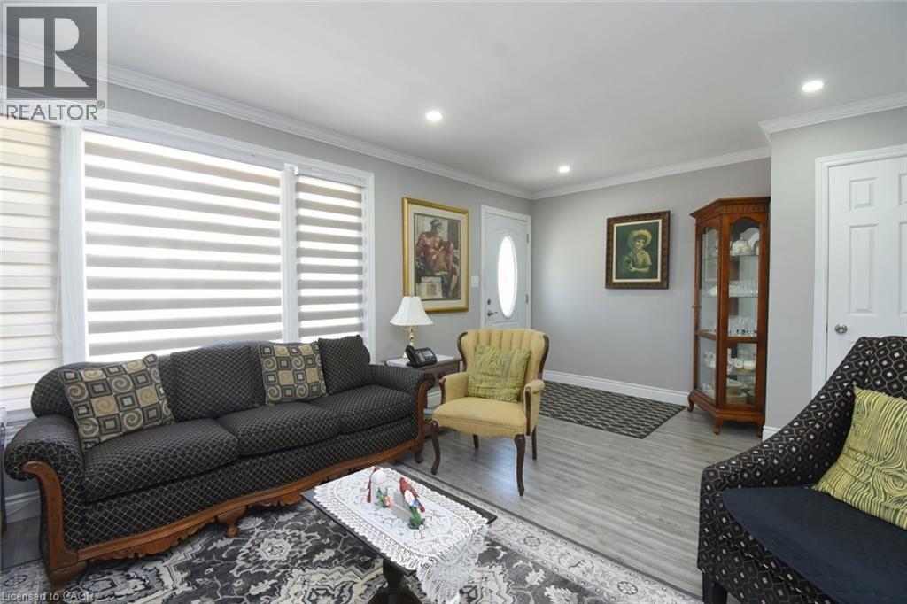 Spacious living area featuring light wood-finish flooring, recessed lighting, and crown molding - 185 Rosslyn Avenue N, Hamilton, ON - Indoor Photo Showing Living Room