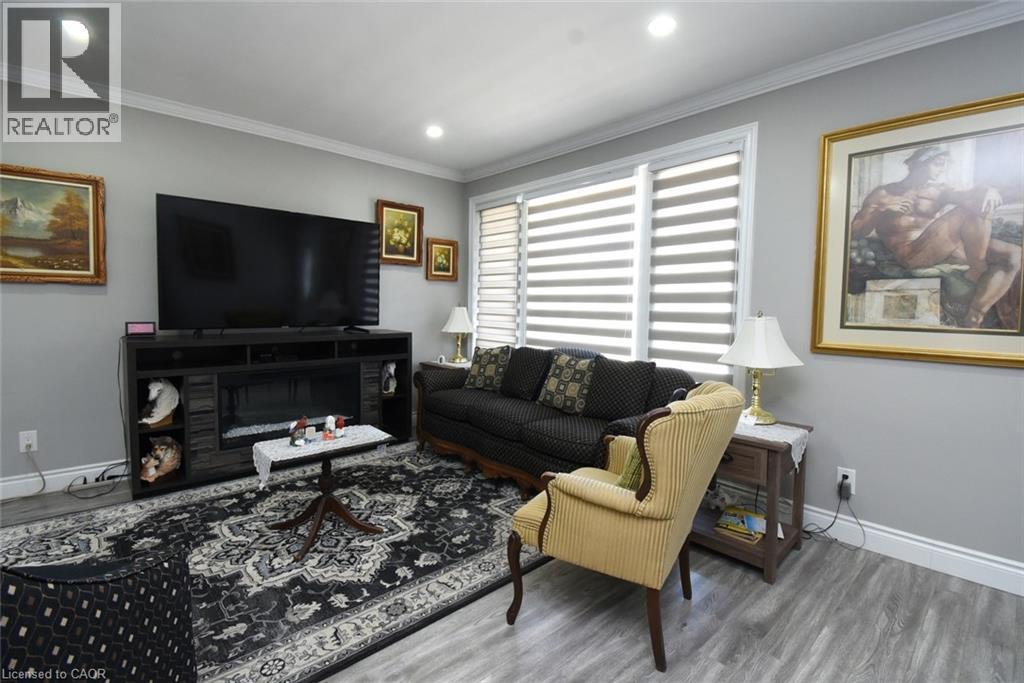 Living area featuring recessed lighting, light gray walls, white crown molding, and wood-finish flooring - 185 Rosslyn Avenue N, Hamilton, ON - Indoor Photo Showing Living Room