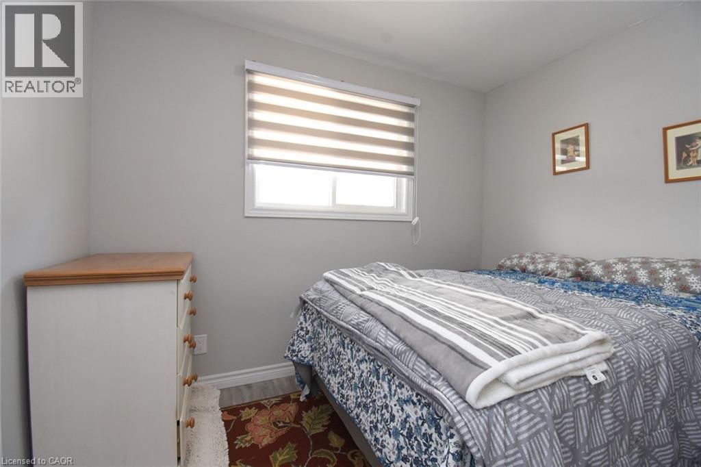 Neutral-toned walls complement the window with banded shades - 185 Rosslyn Avenue N, Hamilton, ON - Indoor Photo Showing Bedroom