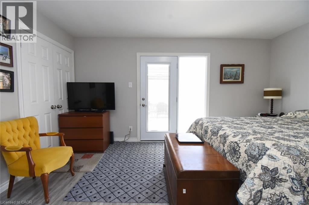 Wood-finish flooring with a patterned area rug, light gray wall paint, and white trim - 185 Rosslyn Avenue N, Hamilton, ON - Indoor Photo Showing Bedroom