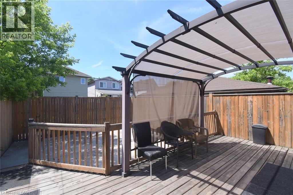 Expansive wood-finish deck featuring a covered pergola with retractable shade panels, and privacy curtains - 185 Rosslyn Avenue N, Hamilton, ON - Outdoor With Deck Patio Veranda With Exterior