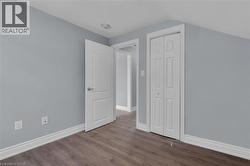 Room featuring wood-finish flooring, light gray wall paint, and white trim -