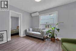 Interior space featuring wood-finish flooring, light grey painted walls, and white baseboards -