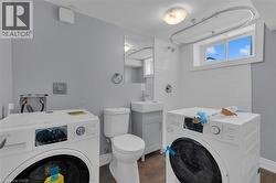 Compact laundry area featuring new front-load washing machines -