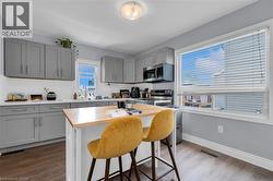 Modern kitchen featuring grey shaker-style cabinetry, white countertops, and a subway tile backsplash -