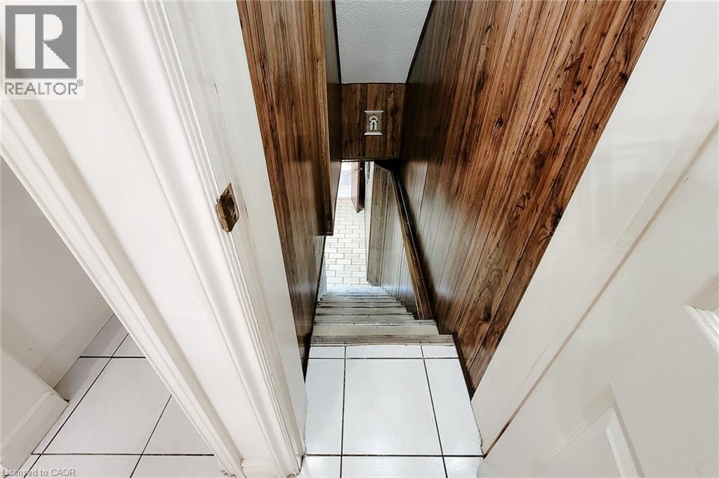Stairwell with wood-finish wall paneling and white trim - 244 Hughson Street N, Hamilton, ON