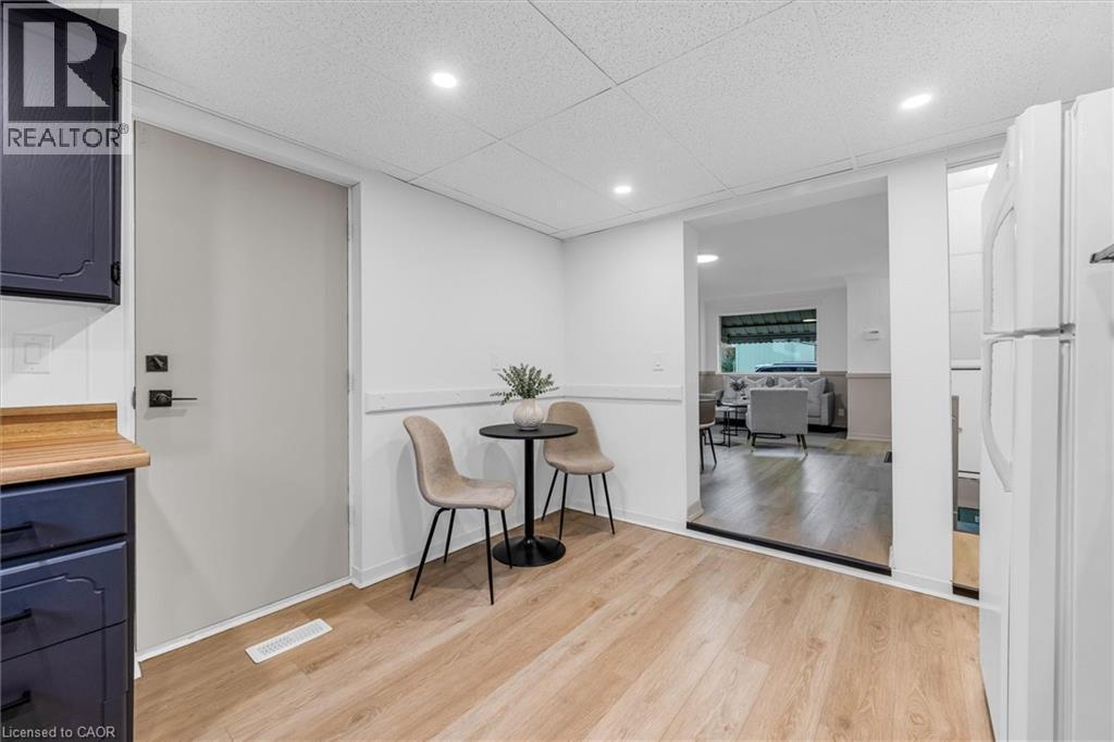 Open-concept area featuring light wood-finish flooring, white walls, and recessed lighting - 11 Ford Street, Hamilton, ON