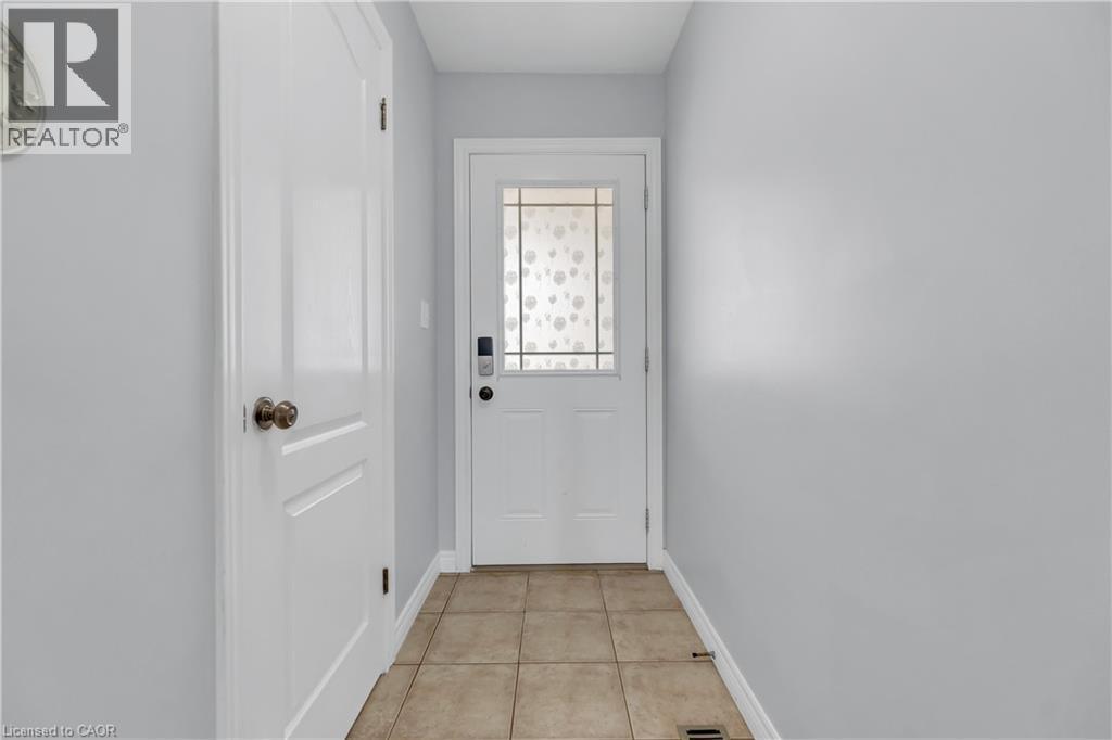 Entryway featuring light neutral wall paint, white trim, and a white paneled door with a decorative glass insert - 48 Clough Crescent, Guelph, ON