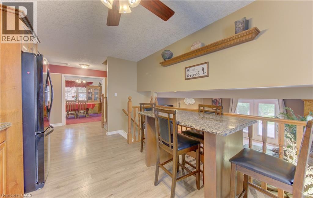 Kitchen with wood-finish flooring, light wood cabinetry, and a black refrigerator - 599 Coldstream Drive, Waterloo, ON