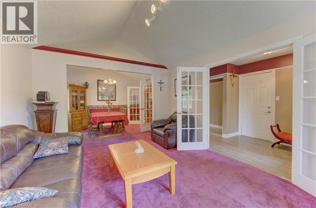 Carpeted living area with a vaulted ceiling and track lighting - 599 Coldstream Drive, Waterloo, ON