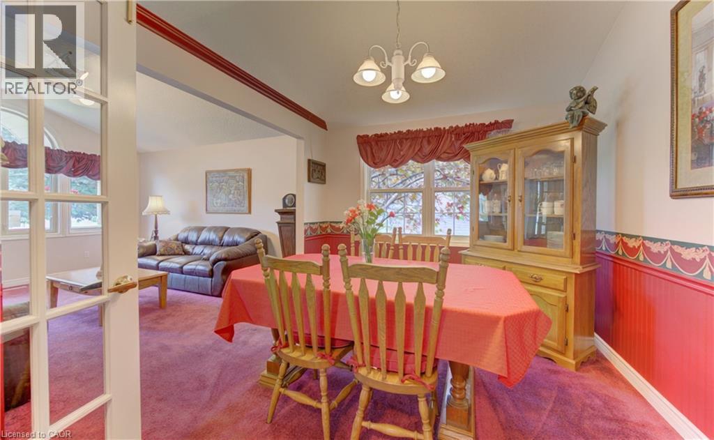 Dining area featuring wainscoting, a bay window, and a three-light chandelier - 599 Coldstream Drive, Waterloo, ON