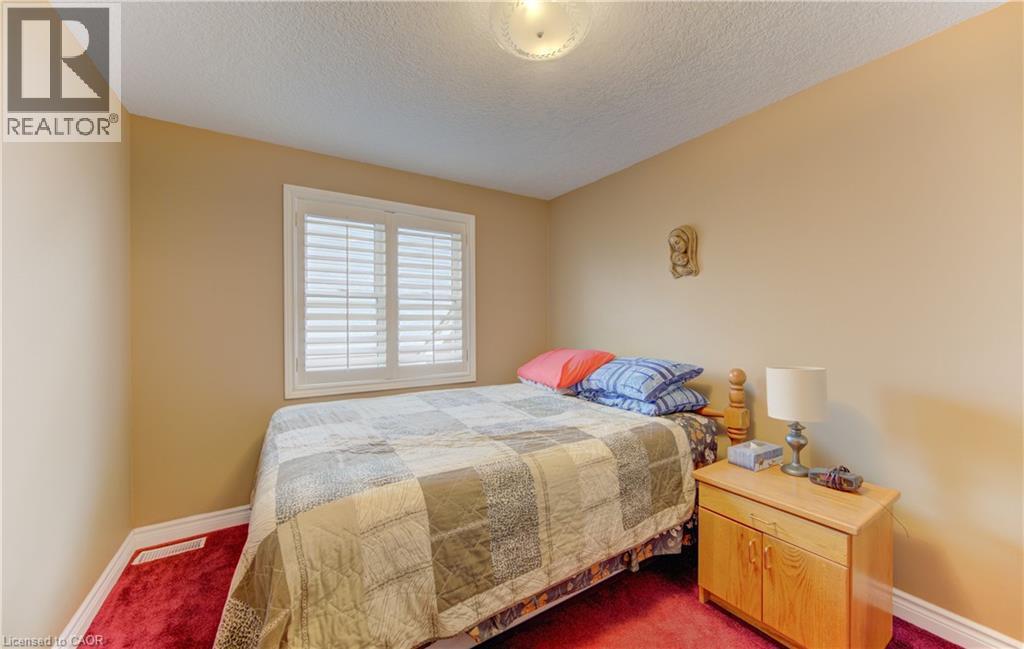 Room featuring warm neutral wall tones and red-hued carpeting - 599 Coldstream Drive, Waterloo, ON