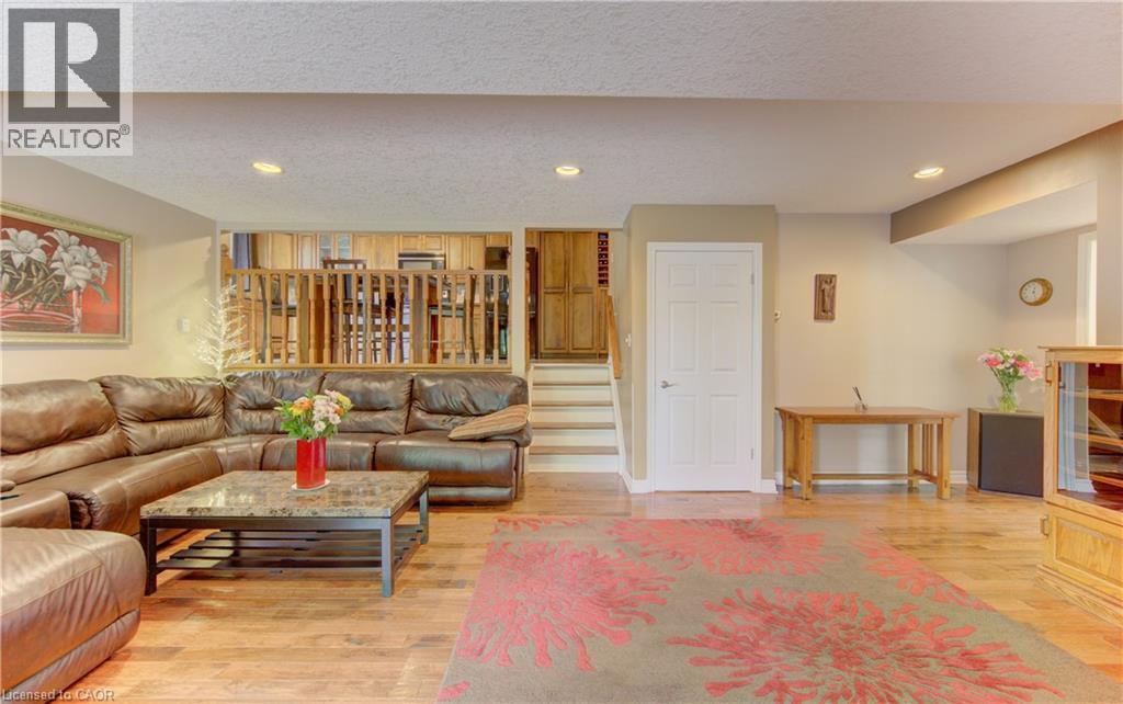Spacious room featuring wood-finish flooring, recessed lighting, and a neutral color palette - 599 Coldstream Drive, Waterloo, ON