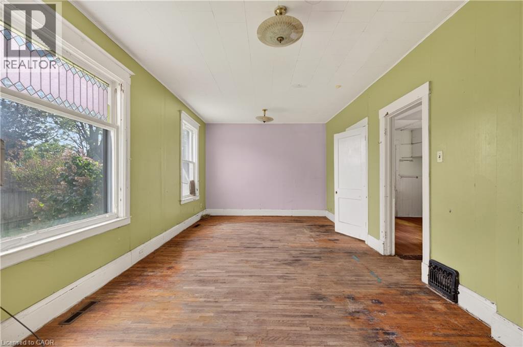 Spacious room featuring wood-finish flooring, white trim, and a window with a stained-glass upper pane - 26 Arthur Avenue, St. Thomas, ON - Indoor Photo Showing Other Room