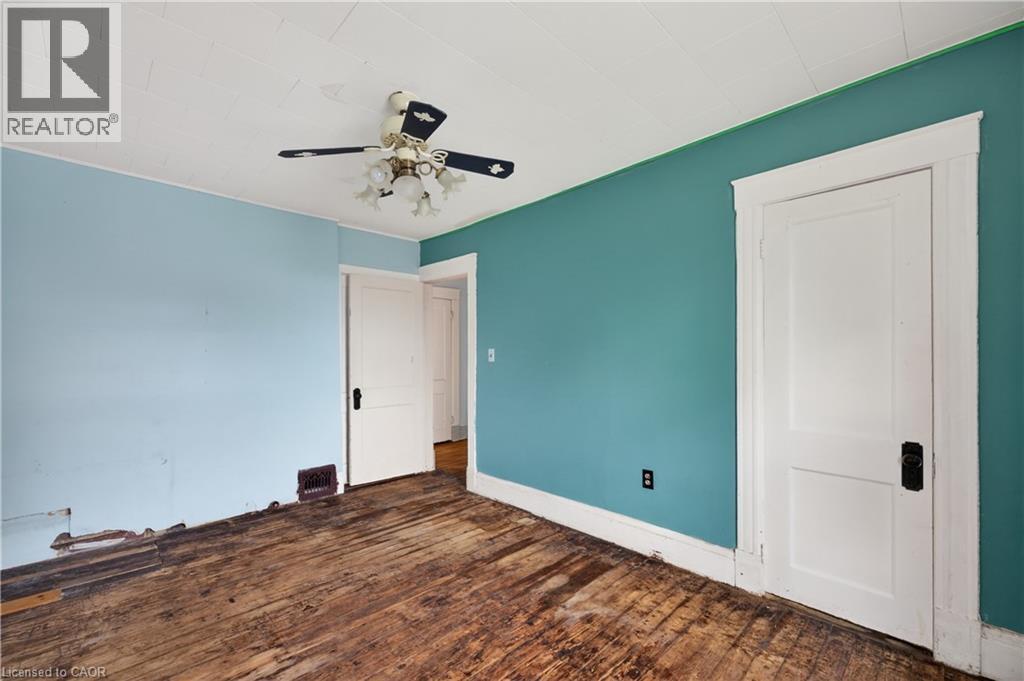 Room featuring two-panel interior doors with black hardware, a ceiling fan with integrated lighting, and crown molding - 26 Arthur Avenue, St. Thomas, ON - Indoor Photo Showing Other Room