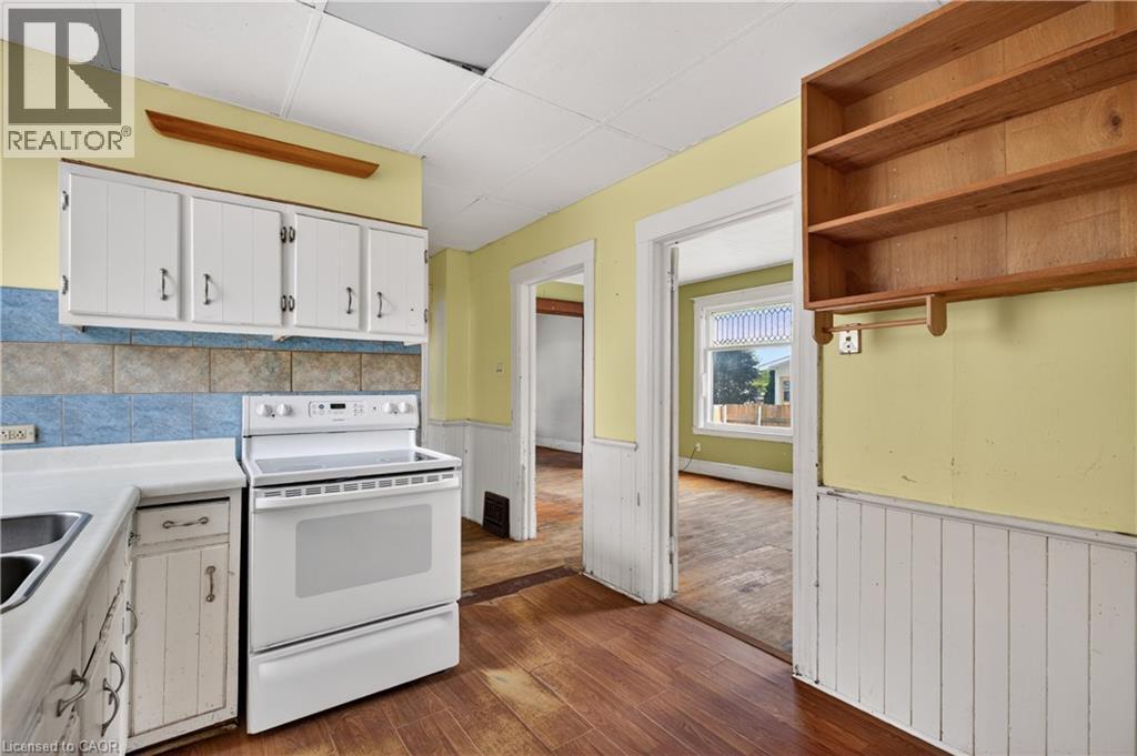 Kitchen area featuring white cabinetry, a dual-basin sink, and a standalone electric range - 26 Arthur Avenue, St. Thomas, ON - Indoor Photo Showing Kitchen