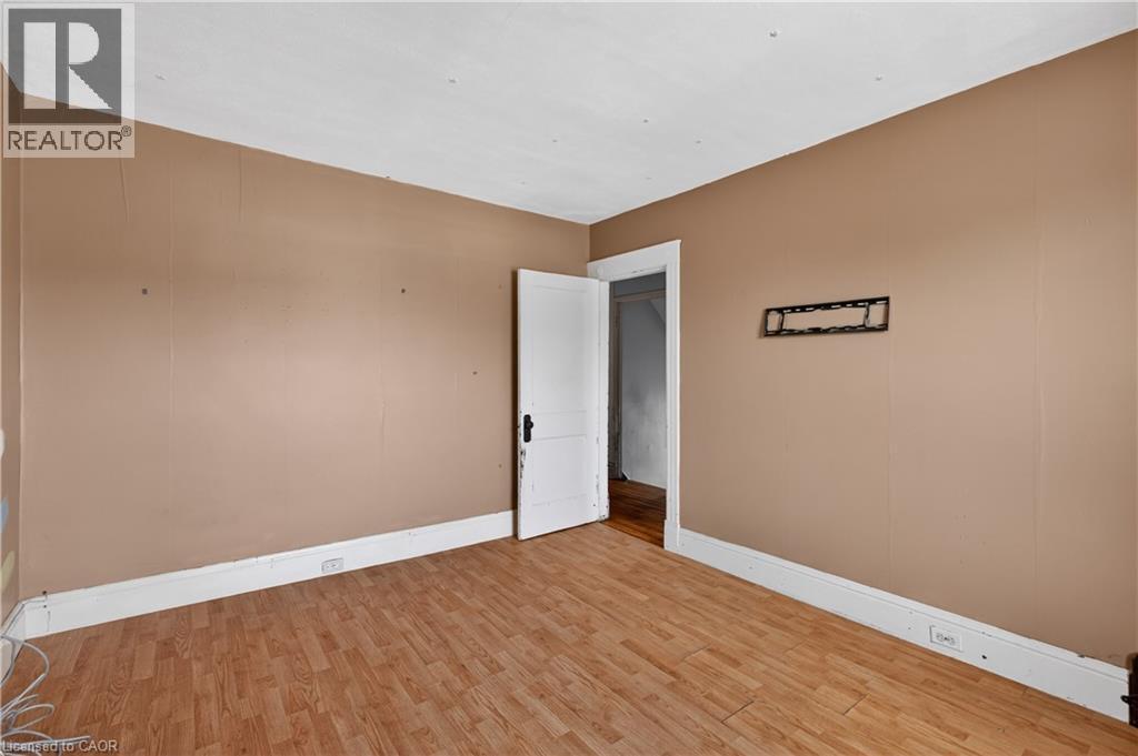 Room featuring wood-finish flooring, neutral wall tones, white trim, and a white interior door - 26 Arthur Avenue, St. Thomas, ON - Indoor Photo Showing Other Room