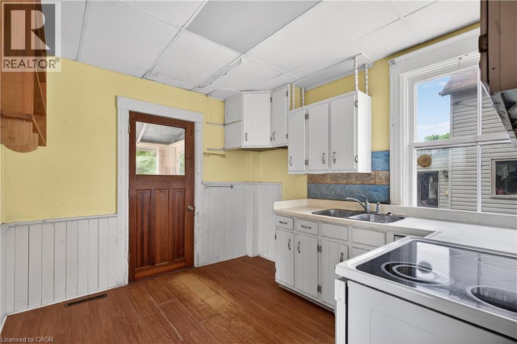 Kitchen featuring light cabinetry, a double basin sink, and a built-in electric stovetop - 26 Arthur Avenue, St. Thomas, ON - Indoor Photo Showing Kitchen With Double Sink