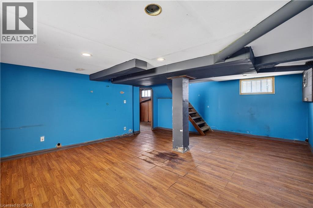 Spacious room with wood-finish flooring, recessed ceiling lighting, a window, and exposed structural beams - 26 Arthur Avenue, St. Thomas, ON - Indoor