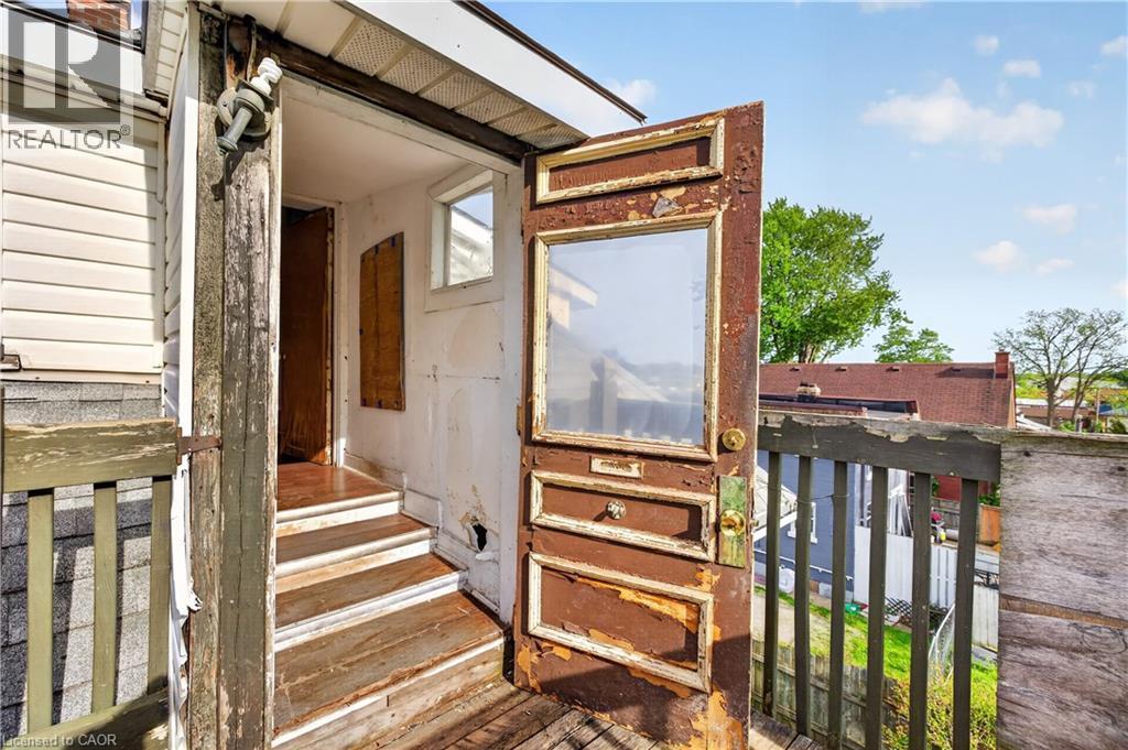 Exterior wooden door with glass pane, wooden railing, and partial siding - 26 Arthur Avenue, St. Thomas, ON - Outdoor