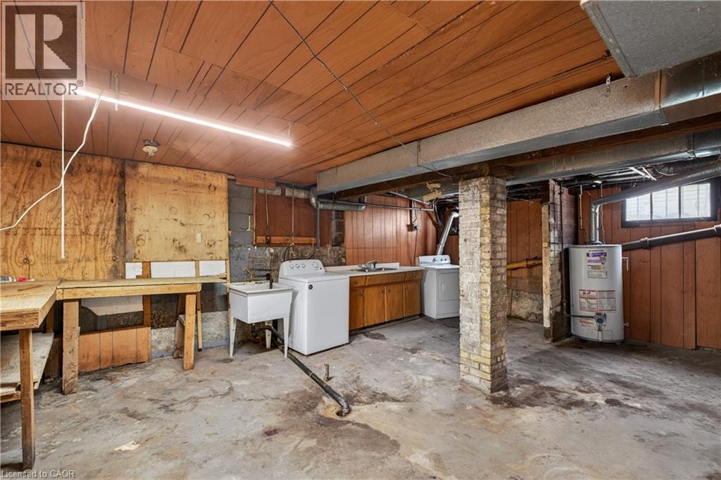 Utility space featuring a laundry area with washer connection, a utility sink, and wood-finish paneling - 26 Arthur Avenue, St. Thomas, ON - Indoor Photo Showing Basement