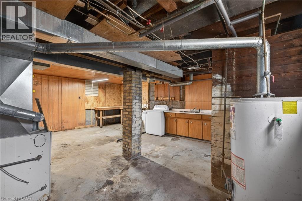 Basement utility area featuring exposed ductwork, brick support columns, and wood paneling - 26 Arthur Avenue, St. Thomas, ON - Indoor Photo Showing Basement