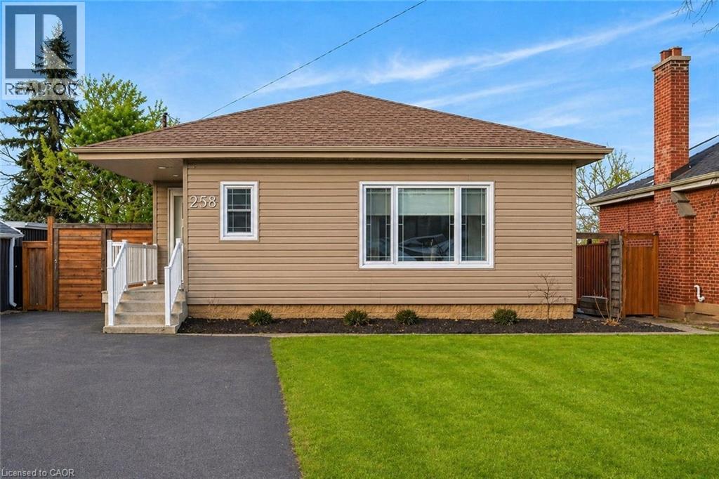 Single-story residence featuring tan siding and a brown shingle roof - 258 Sanatorium Road, Hamilton, ON