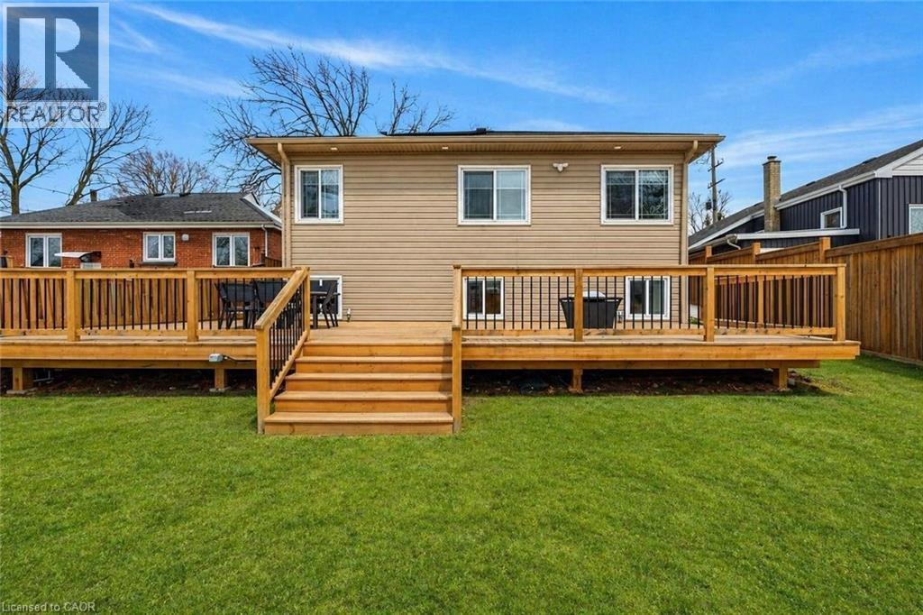 Expansive backyard featuring a manicured lawn, a multi-tiered wood deck with railings, and a siding exterior - 258 Sanatorium Road, Hamilton, ON