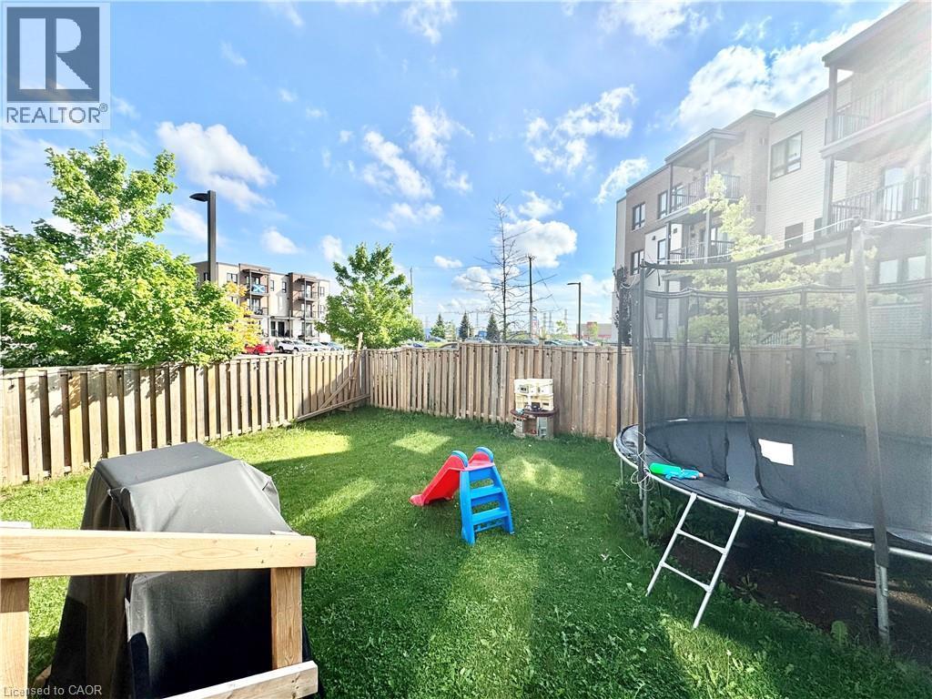 Fenced backyard with established lawn and mature perimeter trees - 1333 Countrystone Drive, Kitchener, ON