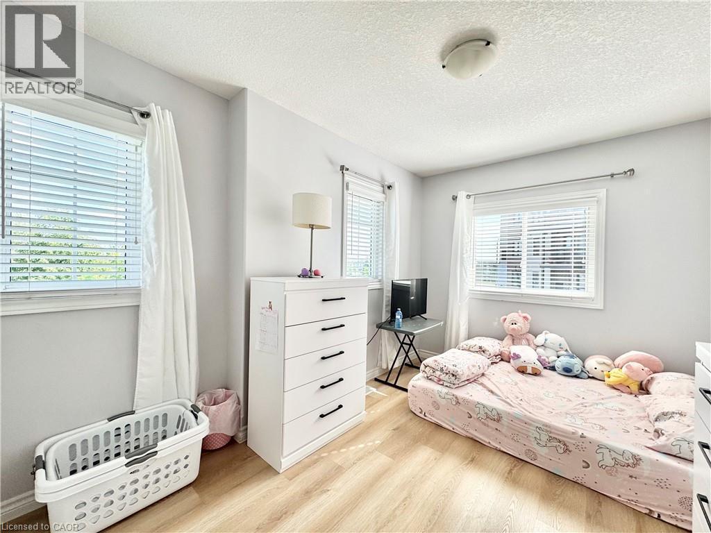 Room featuring wood-finish flooring, light grey walls, and white trim - 1333 Countrystone Drive, Kitchener, ON