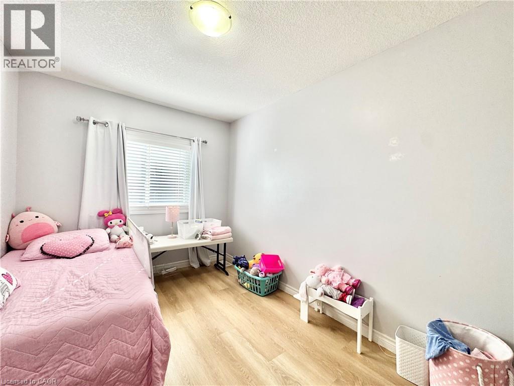 Light wood-finish flooring complements the neutral wall color - 1333 Countrystone Drive, Kitchener, ON