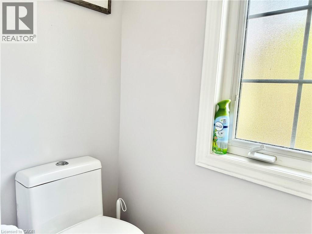 Frosted window offering natural light, white trim, and a modern toilet with a dual-flush mechanism - 1333 Countrystone Drive, Kitchener, ON