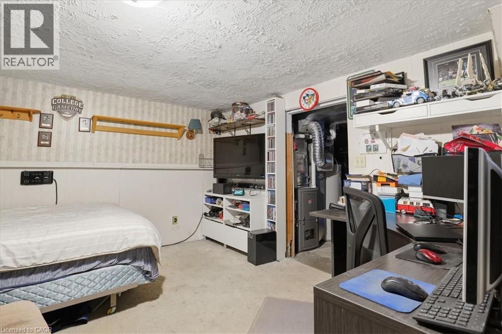 Carpeted room featuring a white paneled wall, striped wallpaper, and a popcorn ceiling - 116 Scott Road, Cambridge, ON