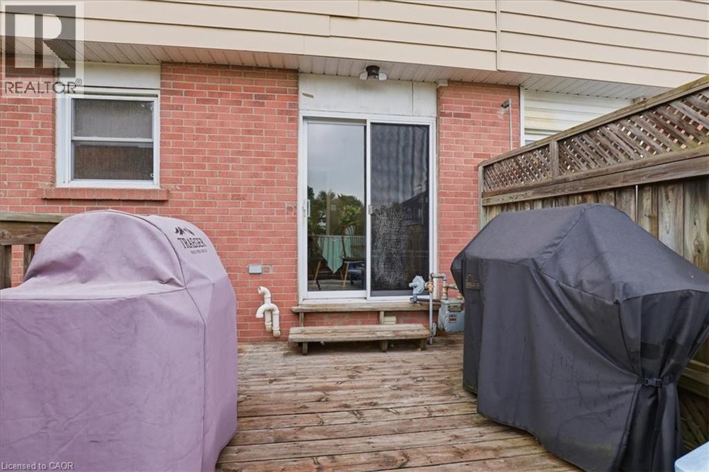 Deck with wood-finish planks featuring a sliding glass door entry - 116 Scott Road, Cambridge, ON