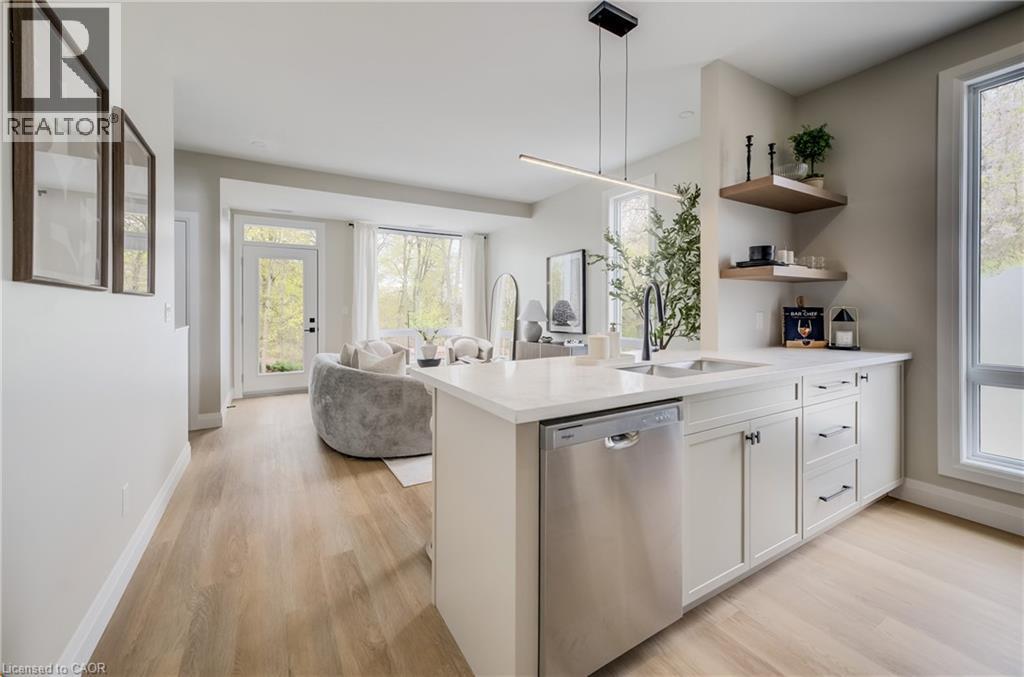 Kitchen island with light-toned cabinetry, stainless steel dishwasher, and an integrated sink with a matte black faucet - 210 Heritage Drive Unit# Upper, Kitchener, ON