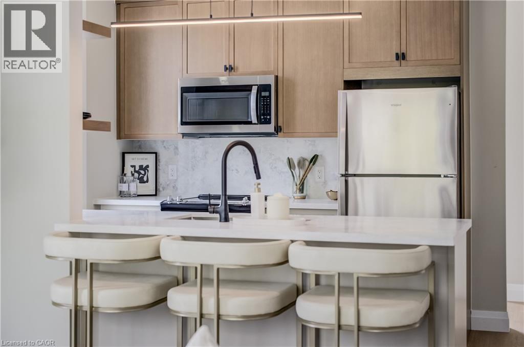 Kitchenette featuring light wood-finish cabinetry, stainless steel appliances, a white countertop, and a black gooseneck faucet - 210 Heritage Drive Unit# Upper, Kitchener, ON