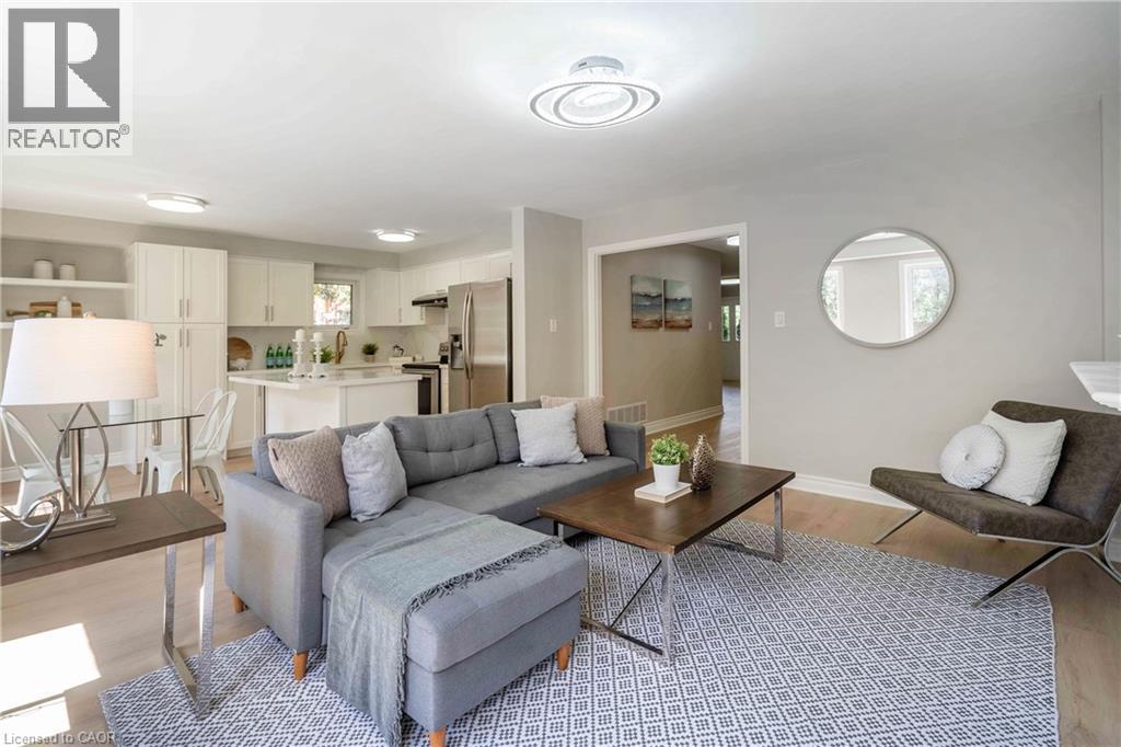 Light-toned wood-finish flooring extends throughout this living area, featuring recessed lighting and a contemporary ceiling fixture - 2425 Nichols Drive, Oakville, ON - Indoor Photo Showing Living Room