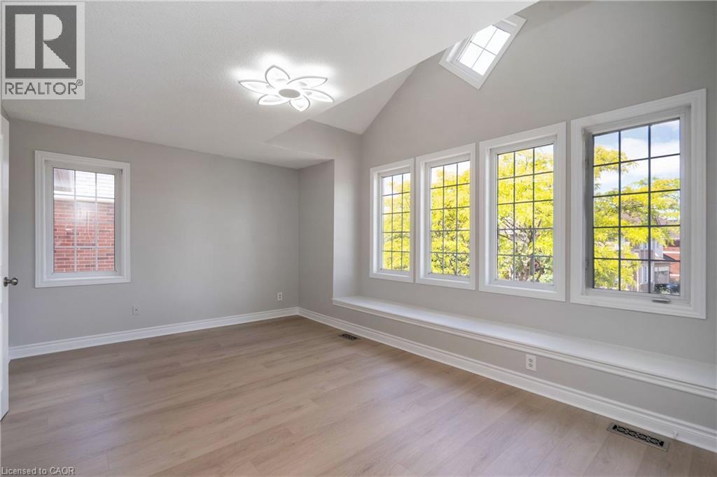 Room featuring wood-finish flooring, a vaulted ceiling, and multiple windows - 2425 Nichols Drive, Oakville, ON - Indoor Photo Showing Other Room