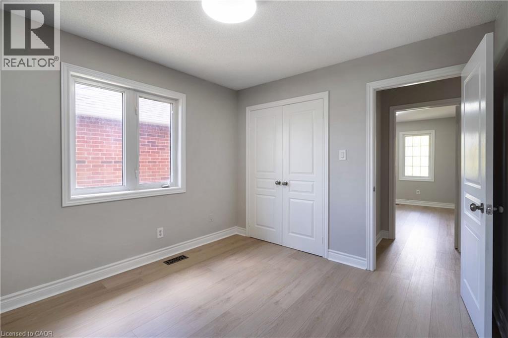 Bright interior space featuring light wood-finish flooring, neutral gray walls, white trim, and a double-door closet - 2425 Nichols Drive, Oakville, ON - Indoor Photo Showing Other Room
