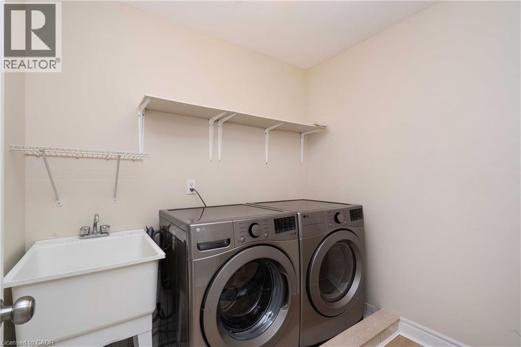 Utility room featuring a built-in wash tub, dual wall-mounted shelving, and a wire drying rack - 2425 Nichols Drive, Oakville, ON - Indoor Photo Showing Laundry Room