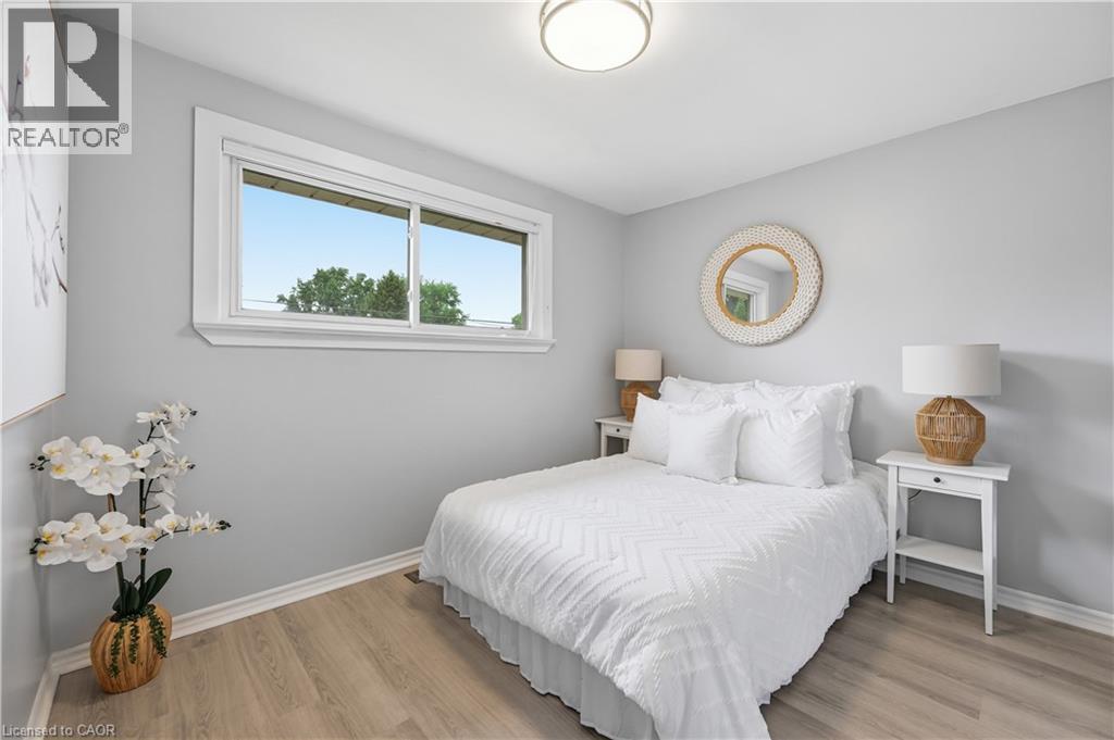 Bright interior space featuring light wood-finish flooring, a contemporary flush mount ceiling light, and a horizontal sliding window with white trim - 189 Foxbar Road, Burlington, ON