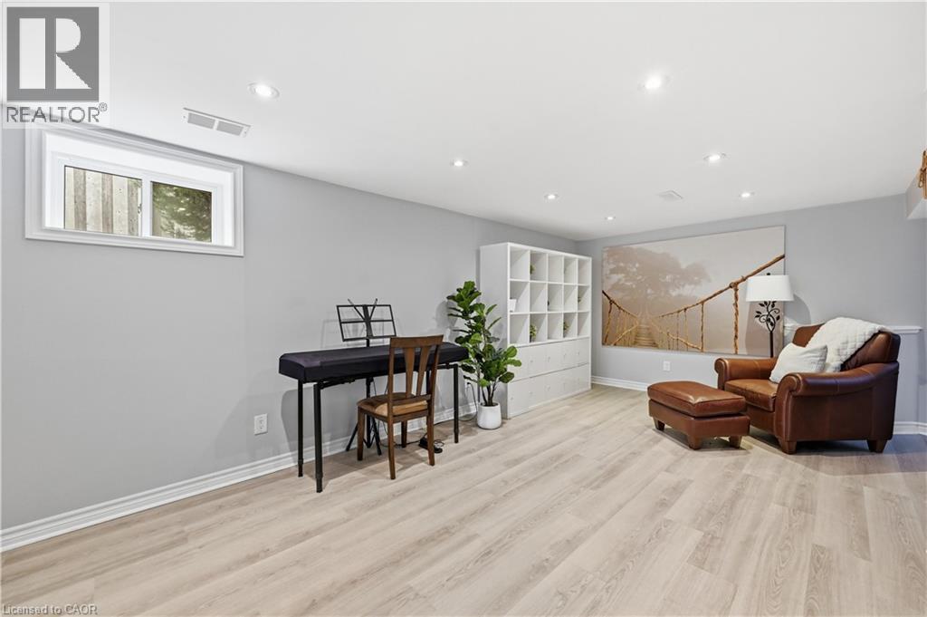 Recessed lighting illuminates the expansive room, featuring light wood-finish flooring and a white trim baseboard - 189 Foxbar Road, Burlington, ON