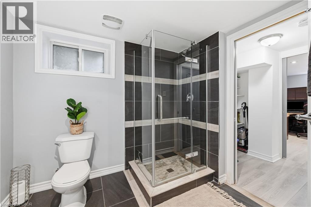 Glass-enclosed shower with dark and light striped tile surround - 189 Foxbar Road, Burlington, ON