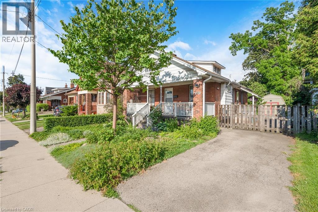Brick and siding exterior with a covered front porch featuring white railings - 295 Keswick Court, Hamilton, ON