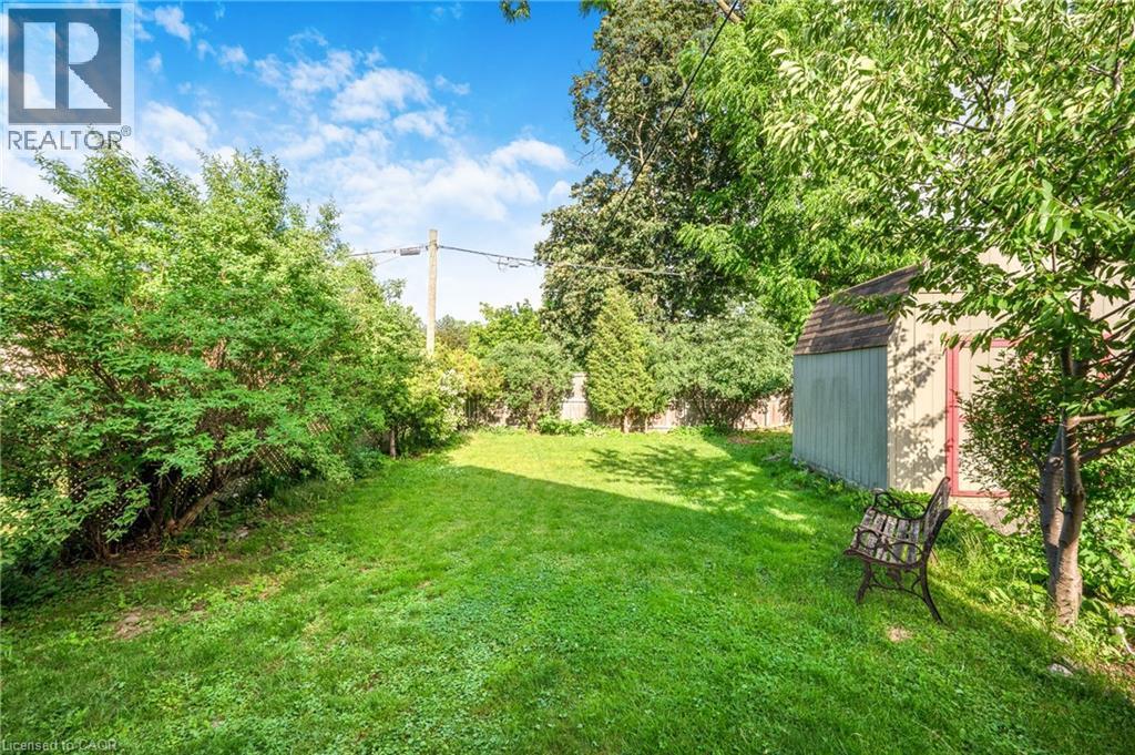 Expansive green lawn surrounded by mature trees and shrubs - 295 Keswick Court, Hamilton, ON