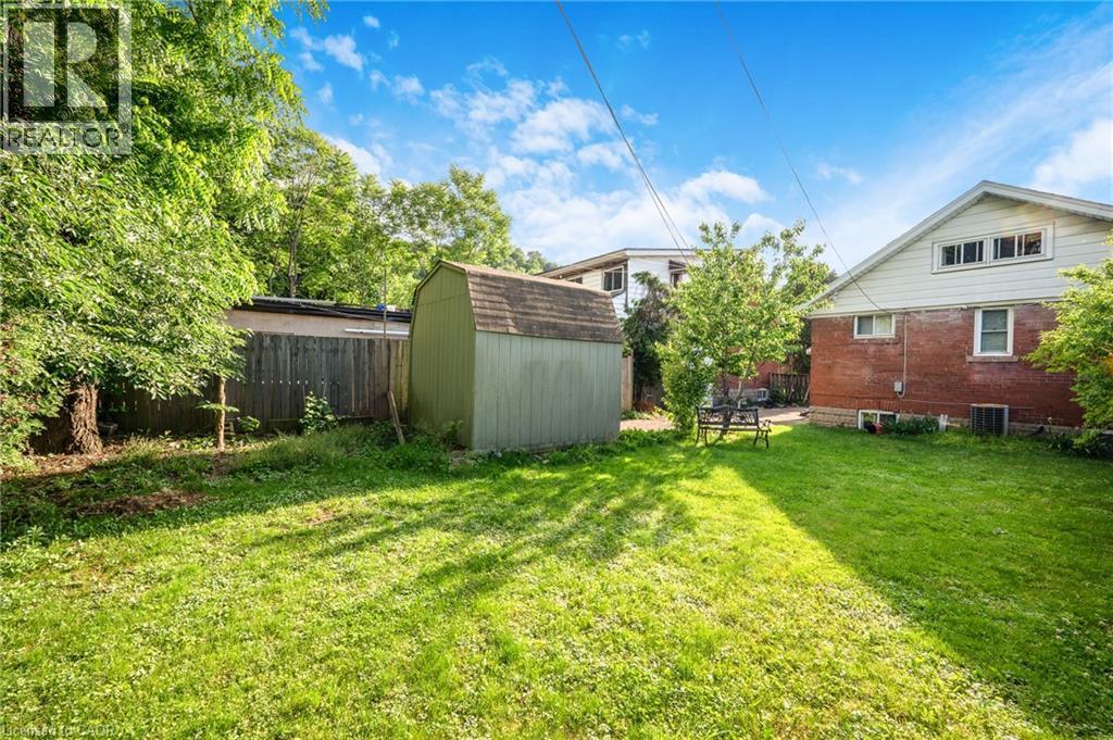 Expansive green lawn with mature trees and a detached storage shed - 295 Keswick Court, Hamilton, ON