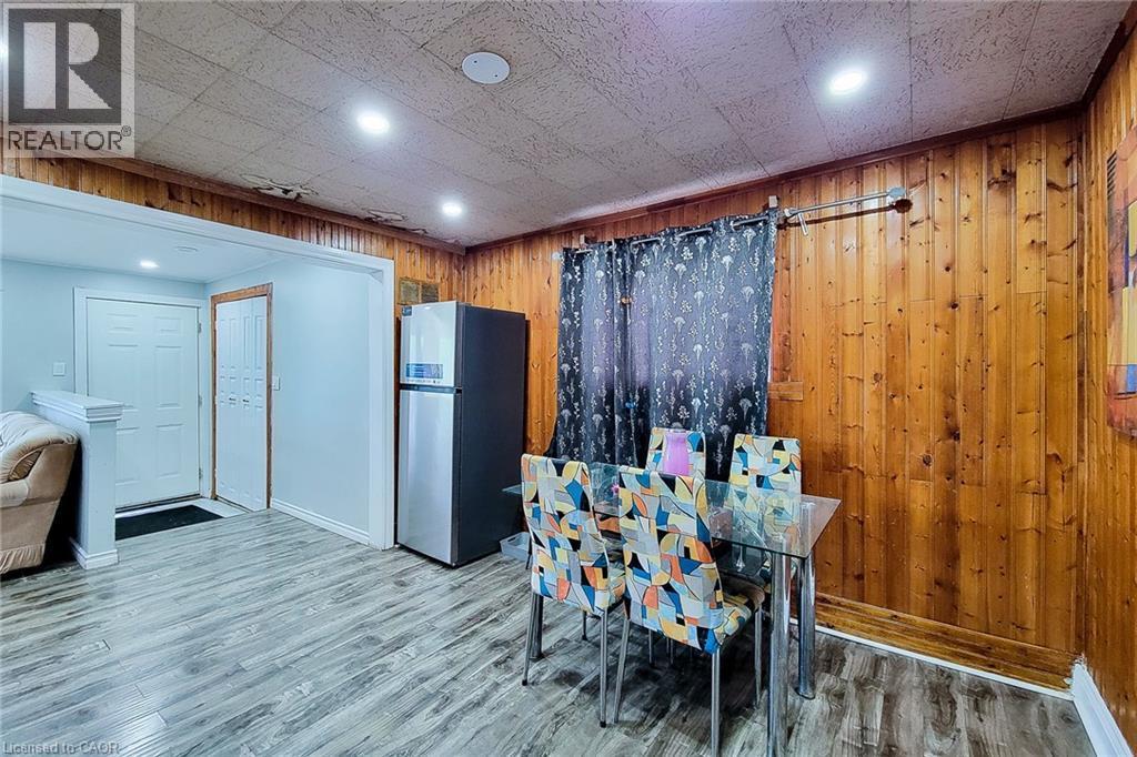 Dining area featuring wood-panel accent walls, wood-finish flooring, and recessed ceiling lighting - 463 Wellington Street N, Hamilton, ON - Indoor Photo Showing Other Room